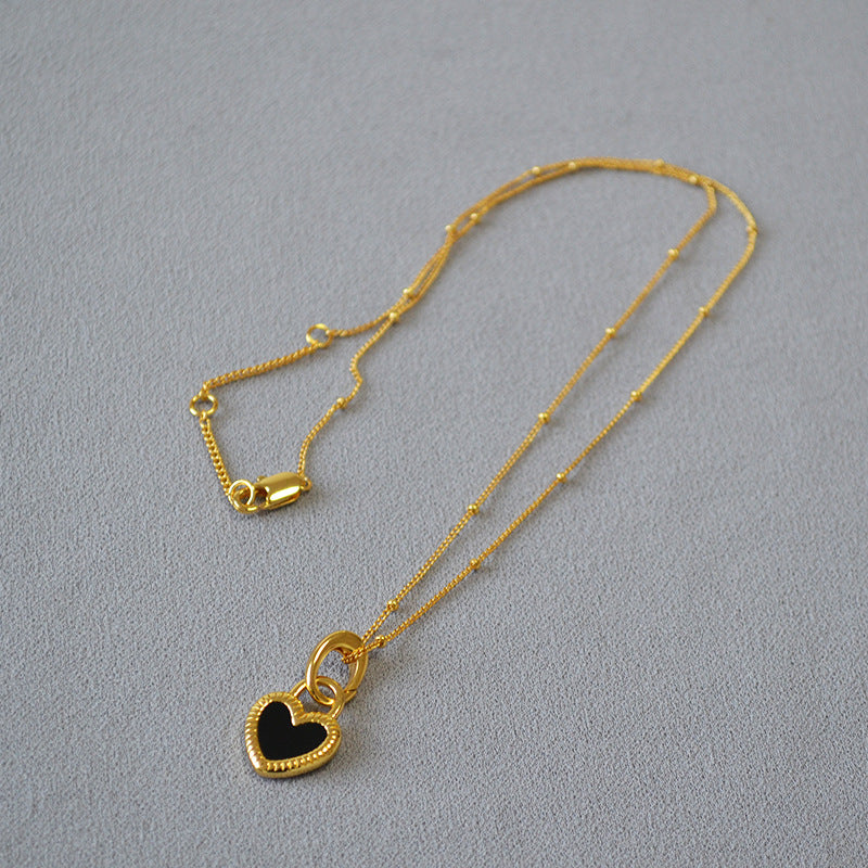 Elegante Herz-Halskette aus Gold mit schwarz-weißen Akzenten