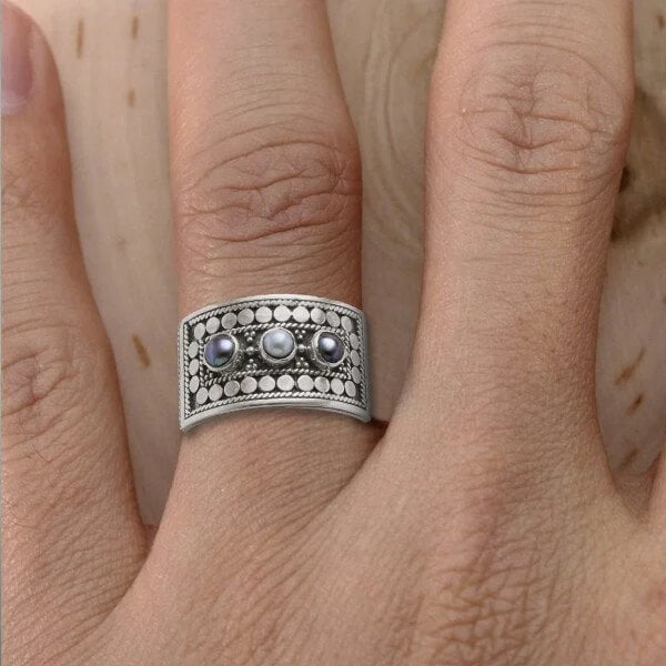 Eleganter geometrischer Ring mit kunstvoll geschnitzter Perle und funkelnden drei Steinen