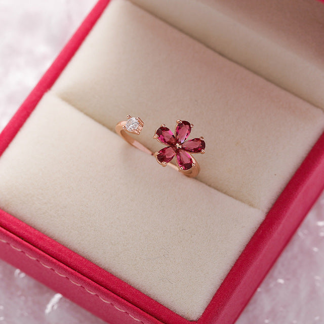 Eleganter verstellbarer Ring mit einer funkelnden roten Kristallblume und edlem goldenen Finish