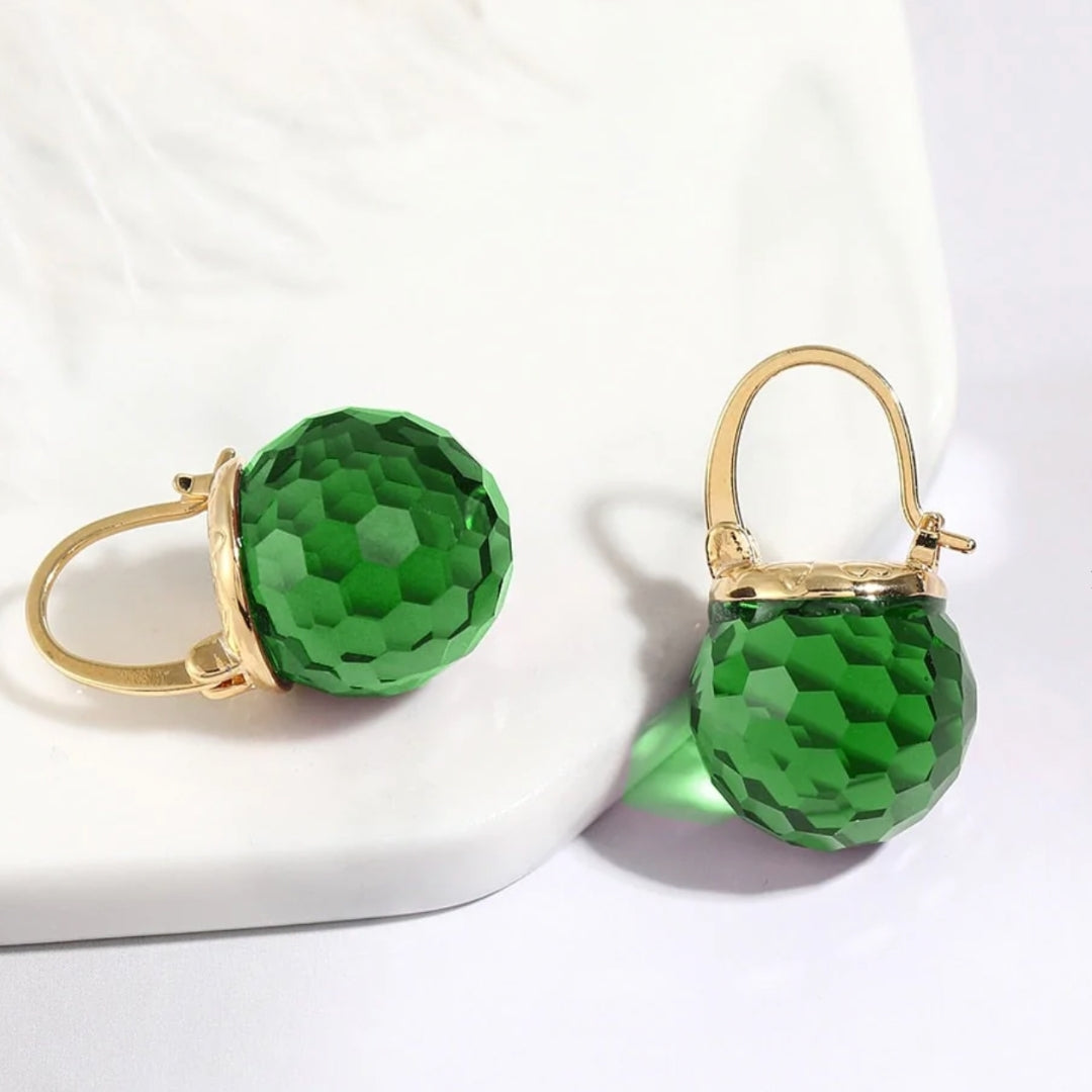 Elegante goldene Ohrringe mit funkelnden grünen Kristallen