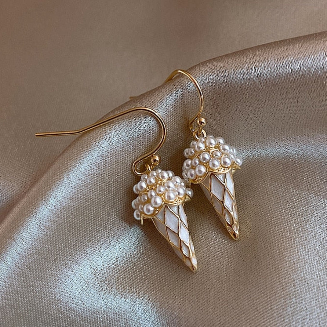 Elegante goldene kegelförmige Ohrringe mit glänzenden Perlen