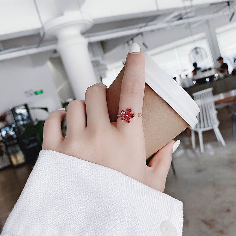 Eleganter verstellbarer Ring mit einer funkelnden roten Kristallblume und edlem goldenen Finish