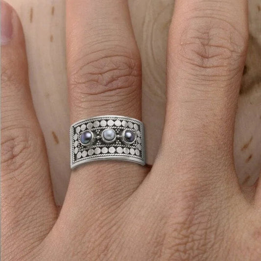 Eleganter geometrischer Ring mit kunstvoll geschnitzter Perle und funkelnden drei Steinen