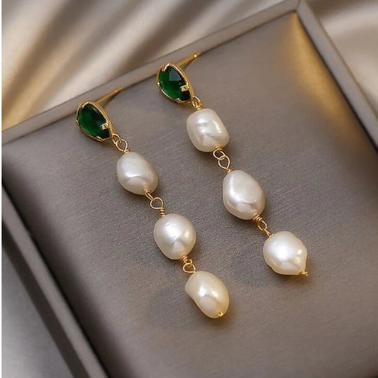 Elegante goldene Ohrringe mit funkelnden Smaragden und edlen Perlen
