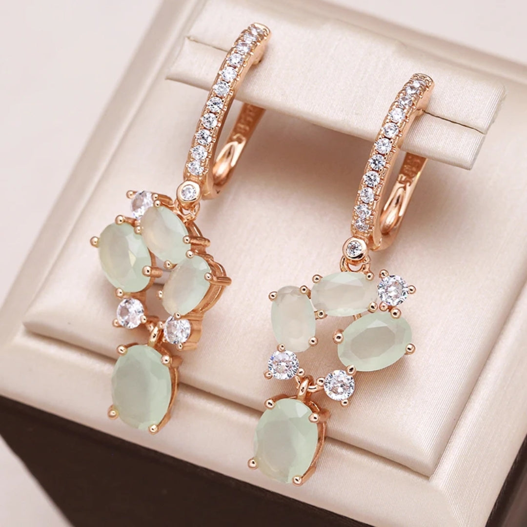 Elegante goldene Ohrringe mit funkelnden grünen Kristallen und Zirkonia
