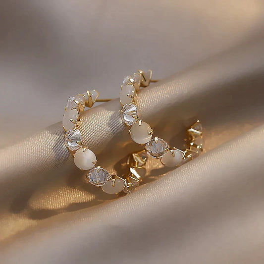 Elegante goldene Ohrringe mit weißen Opalen und funkelnden Zirkonia-Steinen
