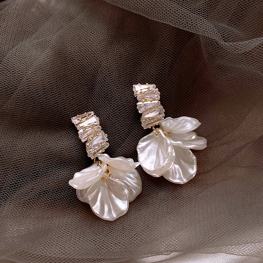 Elegante goldene Ohrringe mit weißen Blütenblättern