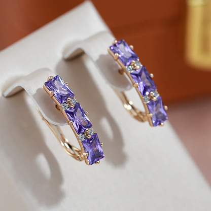 Glamouröse goldene Ohrringe mit strahlenden violetten Kristallen